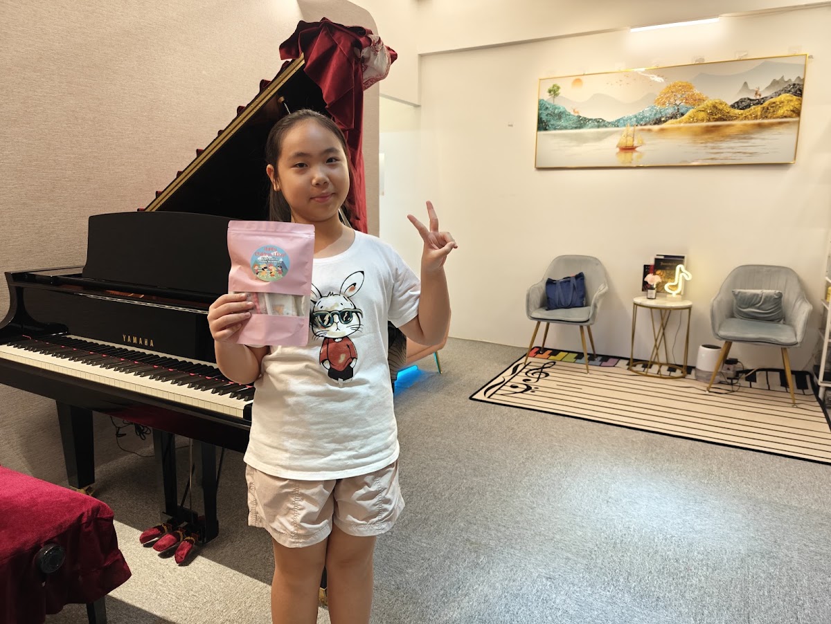 A young student with a small prize from the studio
